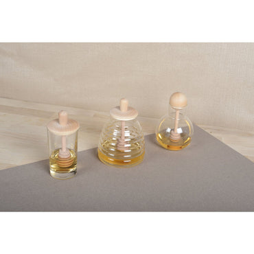 Modern glass honey jar with wooden lid and dipper for serving