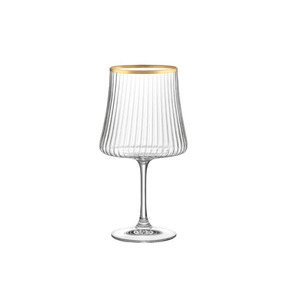 Clear glass wine glass with gold rim on a white background