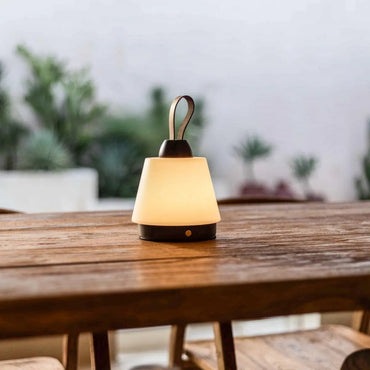 Liv Dark Brown cordless lamp softly glowing on outdoor wooden table