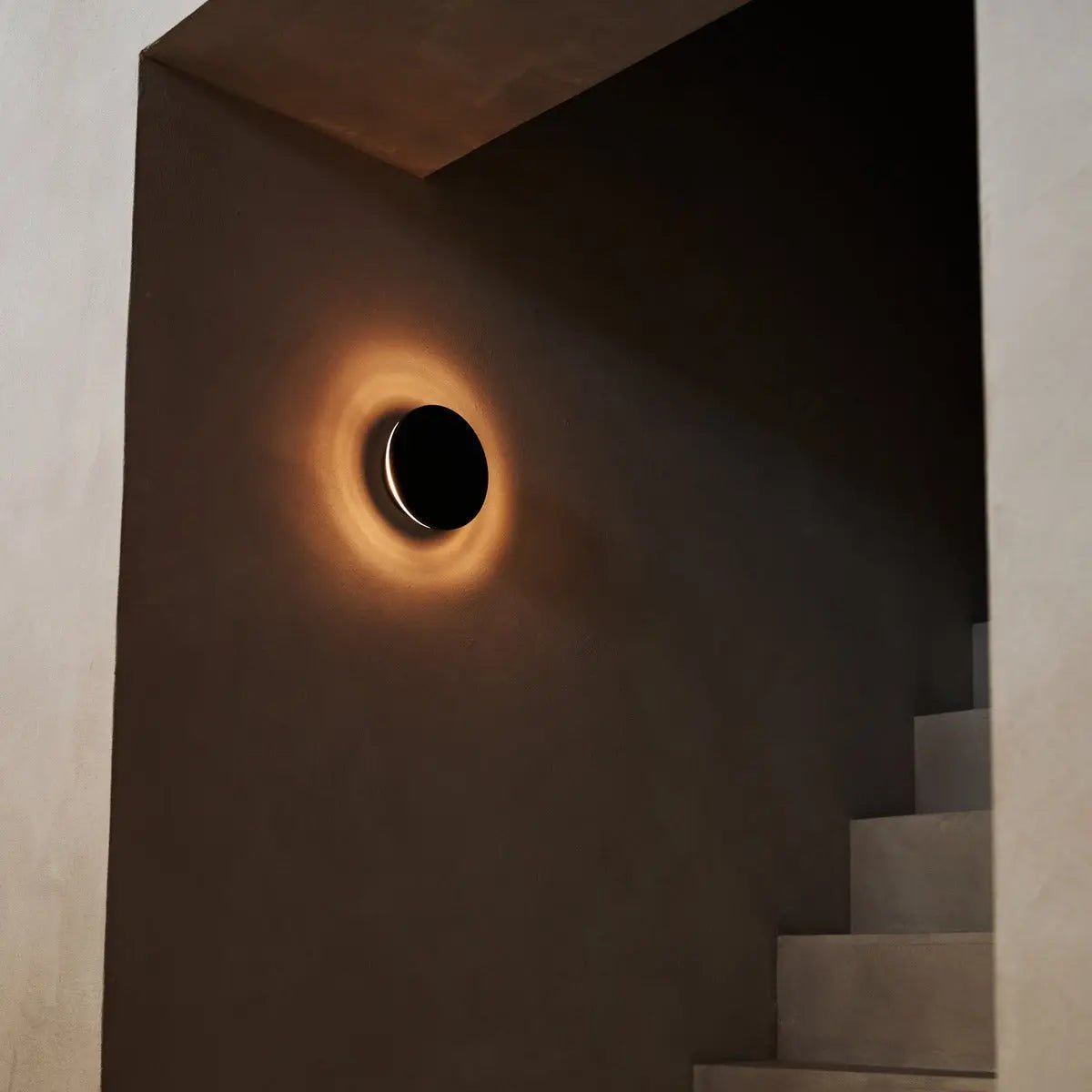 Lou round black wall light emitting cozy warm illumination