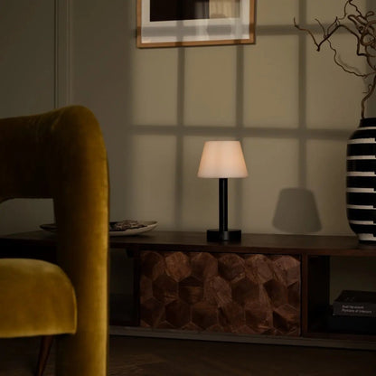 Zoë Black cordless lamp providing warm night light beside sofa