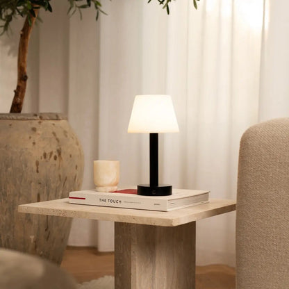 Zoë Black rechargeable table lamp placed on a wooden shelf