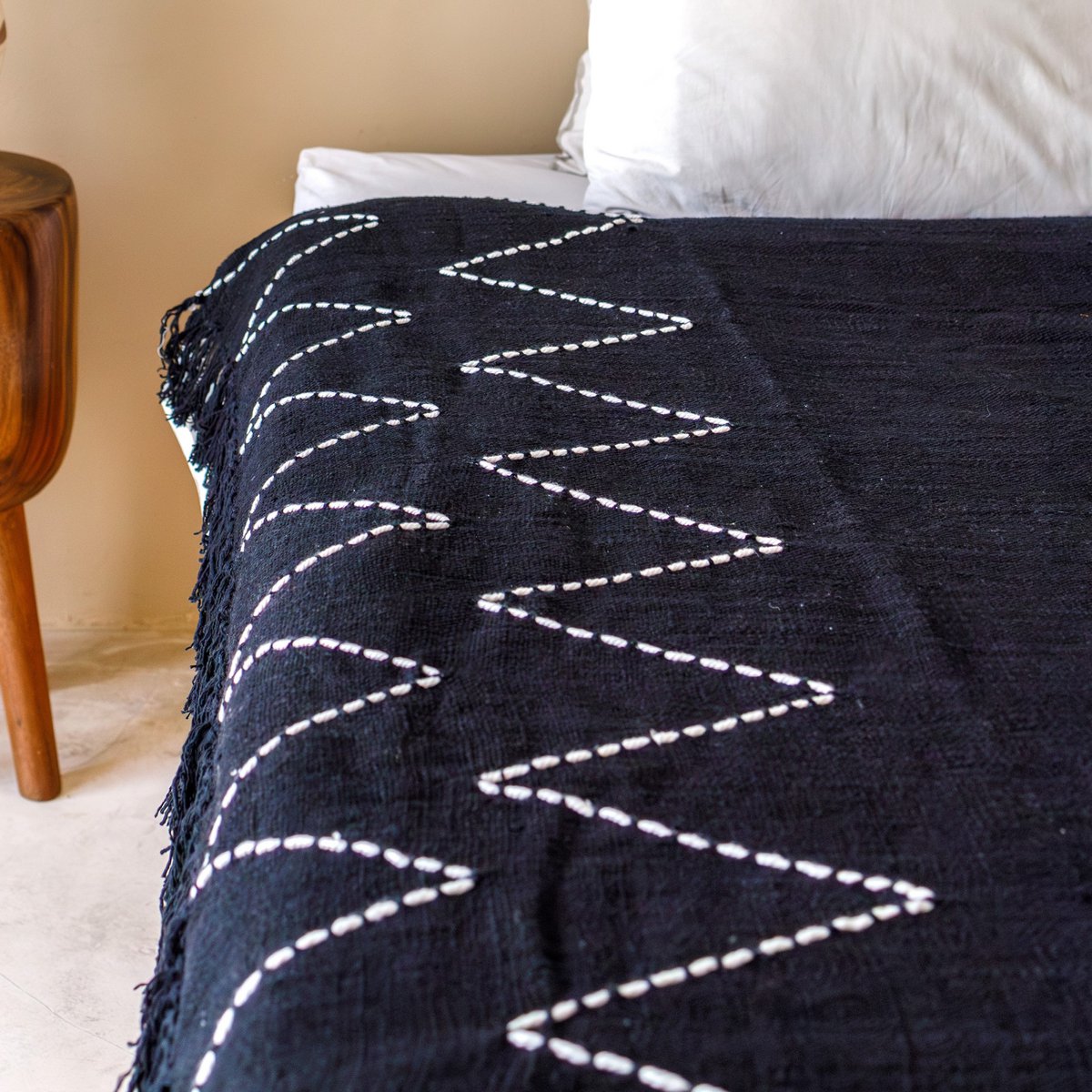 Black Cotton blanket with Boho Zigzag Design folded on sofa