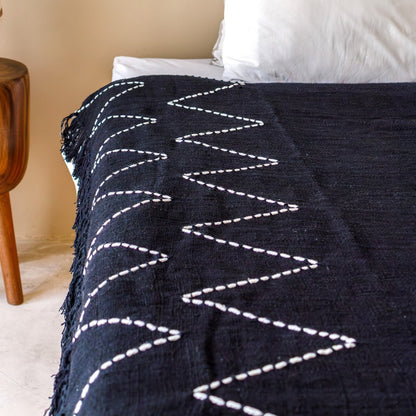 Black Cotton blanket with Boho Zigzag Design folded on sofa