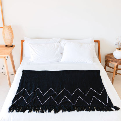Black Handwoven Boho Cotton Blanket with Fringes on white bed
