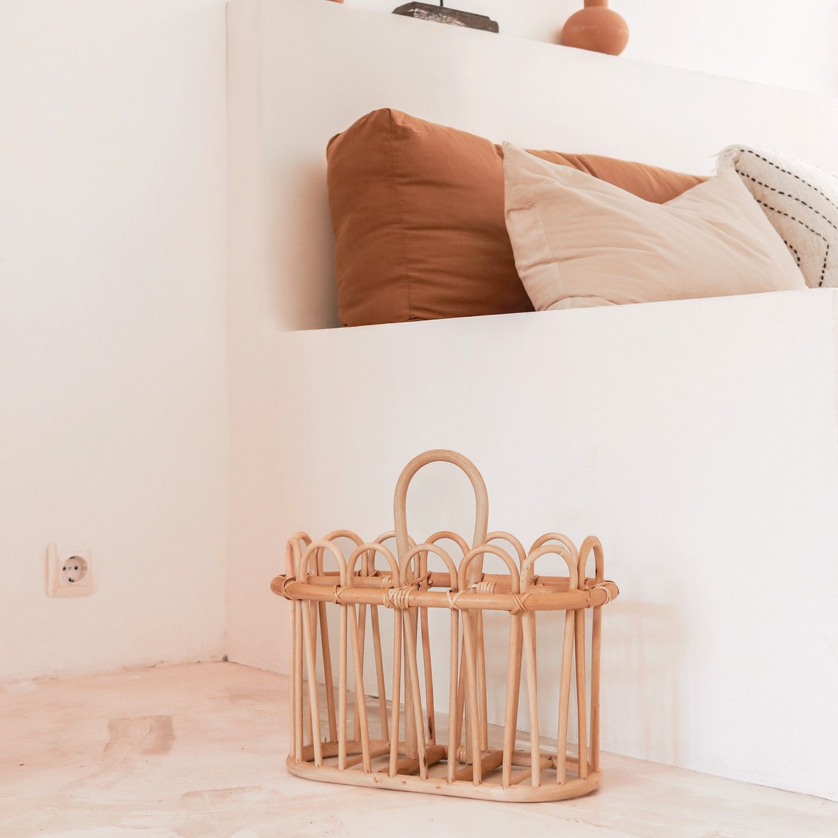Kuno rattan basket for storing newspapers beside living room sofa